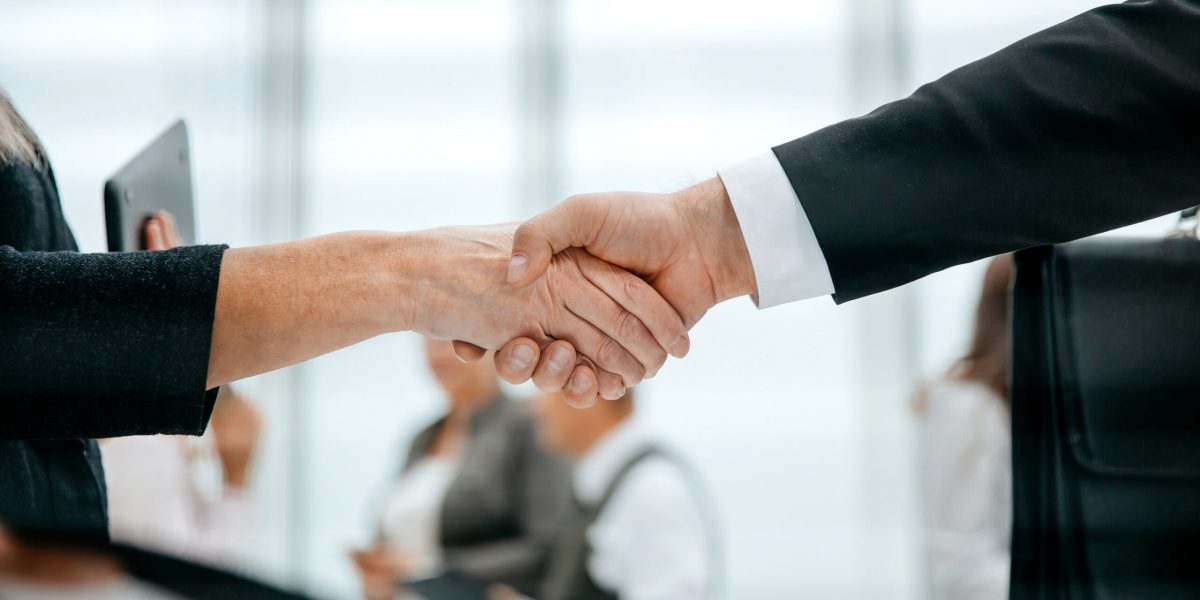 through the blinds. handshake of business people. business concept