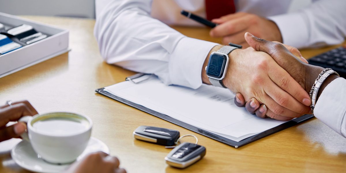 professional-confident-manager-gives-keys-new-car-customer-shakes-hand-him